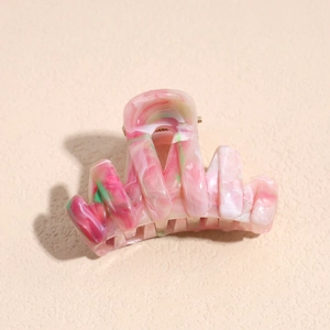 Close-up of pink marble texture hair claw clip with silver metal spring for styling