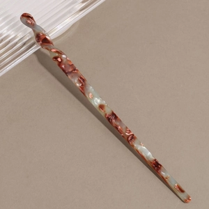Close-up of vintage acetate hair stick with marble texture and spiral twist design