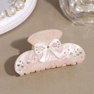 Close-up of pink pearlescent hair claw clip with a 3D butterfly design and crystal accents