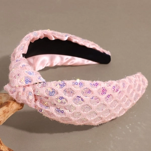 Detailed close-up of pink sequined knot headband featuring sparkling iridescent mesh texture