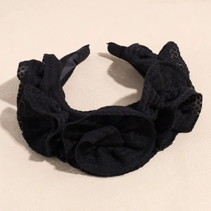Detailaufnahme des schwarzen Spitzen-Haarreifens mit floralen Stoffblüten für Partys