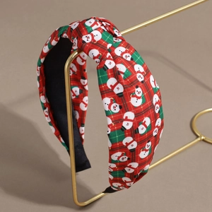 Detail eines rot-grünen Karo-Haarreifens mit Schneemann-Druck und modischem Knoten