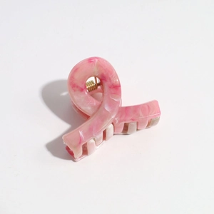 Detail of pink marble gradient hair claw clip with golden spring and twisted design