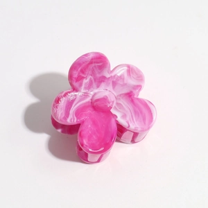 Detailed view of the pink and white marble texture on a floral hair claw clip