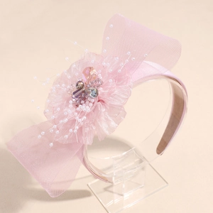 Macro detail of pink mesh headband with delicate pearls and floral crystal accents