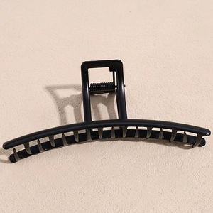 Matte black geometric hair claw clip with large rectangular handle and metal spring detail