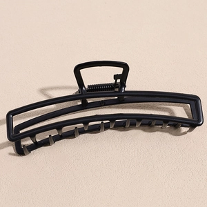 Macro detail of black matte geometric metal hair claw clip with strong spring and teeth