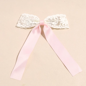 Detail der rosa Satinschleife mit weißer Spitze und eleganten langen Bändern für Haare