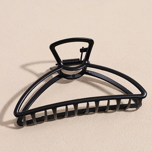 Detail view of the matte black geometric metal hair claw with a minimalist triangular structure