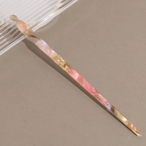 Detailed view of the twisted tortoiseshell acetate hair stick with pearlescent pink texture