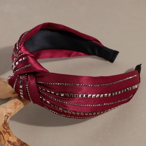 Detail of burgundy satin headband with rhinestone embellishments and knotted side design