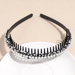 Detalle de diadema antideslizante con perlas blancas y pedrería negra sobre dientes