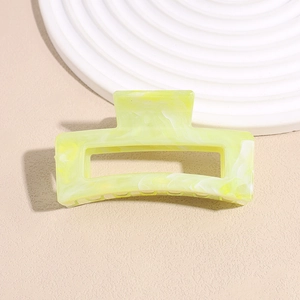Makroaufnahme einer quadratischen fluoreszierenden Haarklammer mit Marmortextur