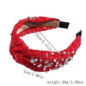 Detail view of a red woven knot headband with pearls, showing dimensions 5cm in width