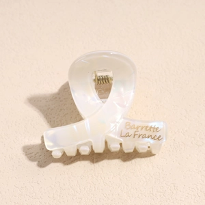 Dettaglio della molletta per capelli in acetato bianco con scritta Barrette La France