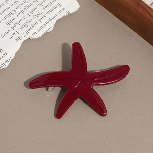 Detailed close-up of a burgundy starfish hair clip with smooth resin finish and silver metal clip