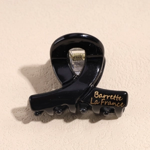 Dettaglio molletta per capelli nera con scritta dorata Barrette La France e molla