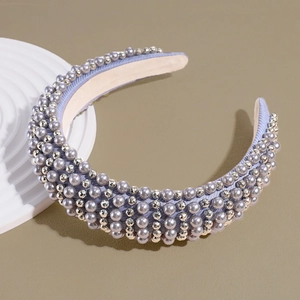 Detail view of a thick sponge headband with grey pearls on a white decorative stand