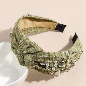 Detailed view of green tweed headband featuring white pearls and sparkling rhinestones