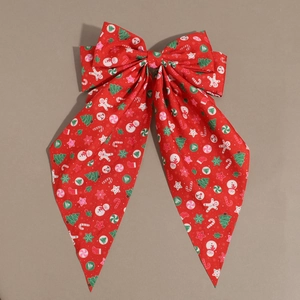 Red Christmas bow hair clip with Santa and gingerbread man patterns on fabric
