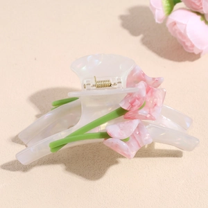 Detailed view of handmade tulip hair claw with pink marble petals and golden spring grip