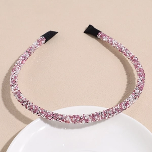 Détails des strass en cristal rose et blanc sur un serre-tête fin en métal scintillant