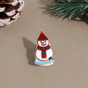 Close-up of a festive snowman hair claw clip with pine cone and needle background