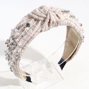 Detail of tweed headband with white pearls and rhinestones on a knot design