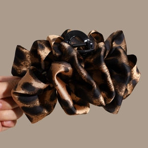 Close-up of leopard print satin fabric hair claw clip with pleated texture design