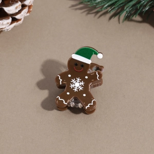 Detail view of mini gingerbread man hair claw clip with Christmas hat and snowflake pattern