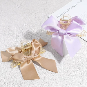 Pinces à cheveux avec nœud en satin lavande et champagne sur fond de style minimaliste