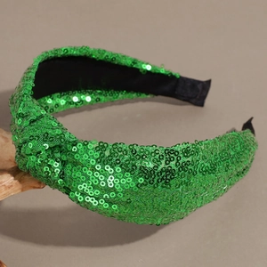 Close-up of green sequin knotted headband with black fabric lining for festive fashion