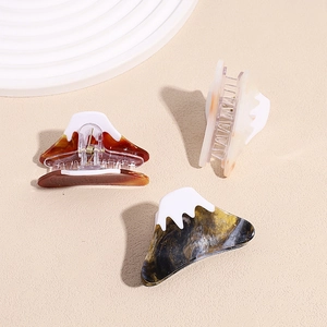 Three acetate Mount Fuji hair claws in amber, cream, and marble with snow-top design