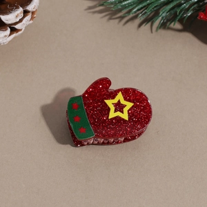 Close-up of a festive red glitter mitten hair claw clip with star details for Christmas