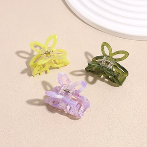 Three hollow butterfly acetate hair claws in yellow, green, and marbled purple patterns