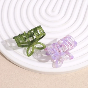 Hollow butterfly acetate hair claws in green and purple marble texture on white tray