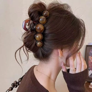 Elegant large amber resin hair claw clip with pearls for women's bun hairstyle