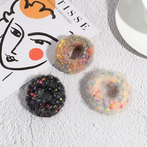 Three-pack of plush polka dot scrunchies in black, beige, and tan colors for women