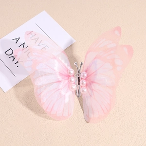 Détail de la pince à cheveux papillon en organza rose avec perles et corps métal