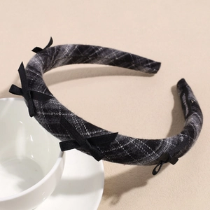 Dettaglio della fascia a scacchi grigi con fiocchi di seta su supporto in ceramica