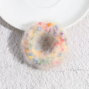 Detail of plush polka dot knitted hair tie with colorful soft fuzzy pom poms