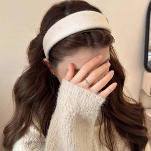 Texture détaillée du bandeau épais en polaire blanche et bague en argent sur modèle