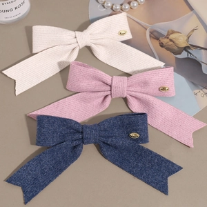 Lot de trois barrettes à nœuds tricotés en crème, rose et bleu marine avec décor doré