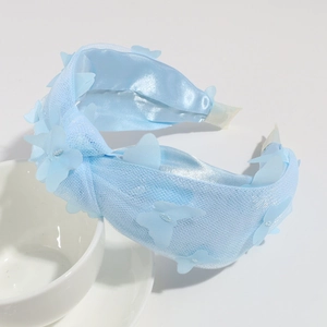 Detail of light blue mesh knot headband with delicate fabric butterfly ornaments