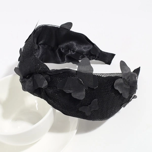 Detail of black mesh headband featuring 3D butterfly ornaments and soft satin inner lining