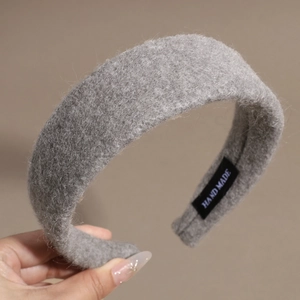 Détail d'un serre-tête en laine grise avec étiquette faite main et texture en peluche