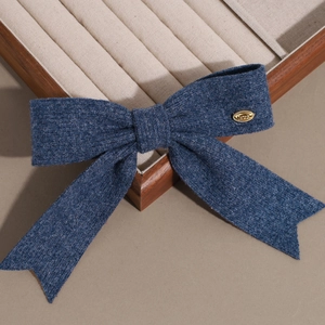 Détail du nœud papillon tricoté bleu marine avec plaque en métal doré LOVE