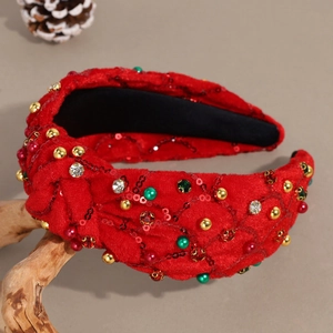 Détail d'un serre-tête de Noël en velours rouge avec strass, sequins et perles colorées