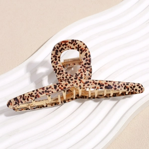 Detail of metal hair claw clip with brown leopard print pattern and golden spring