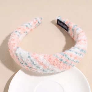 Detail of knit plush headband featuring pastel woven patterns and a hand made label